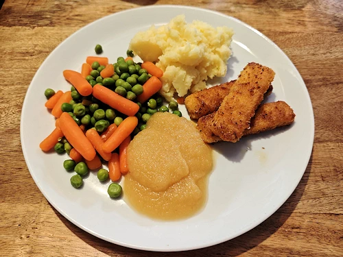 Vissticks met aardappelpuree, doperwten, wortel en appelmoes