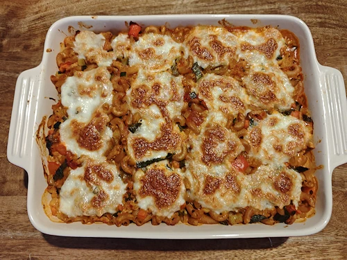 Macaroni-ovenschotel met kipgehakt en groenten, gegratineerd met goudbruine mozzarella.